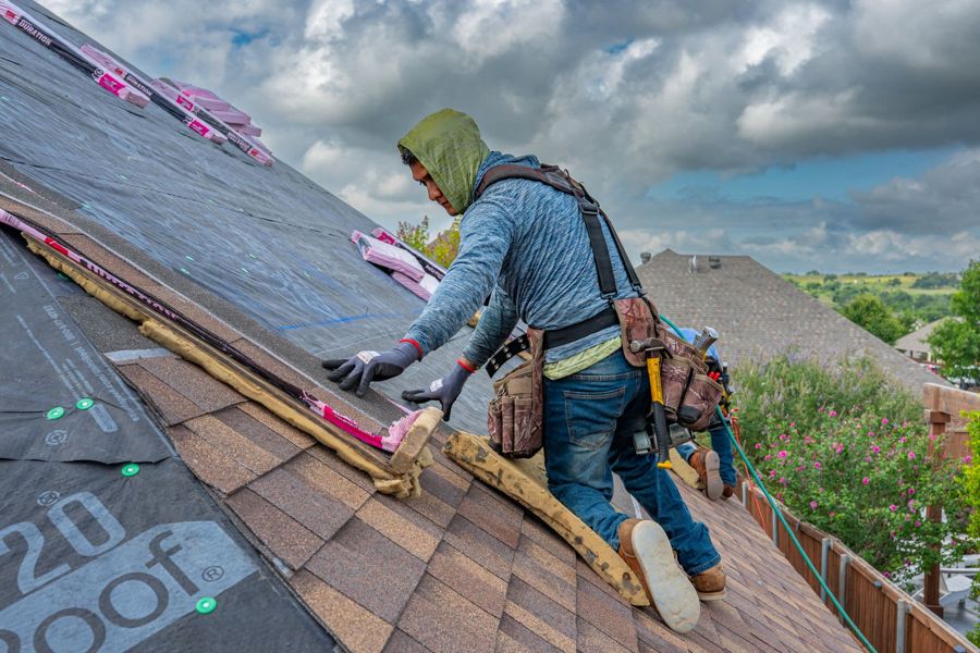 A roofer laying breathable membrane
