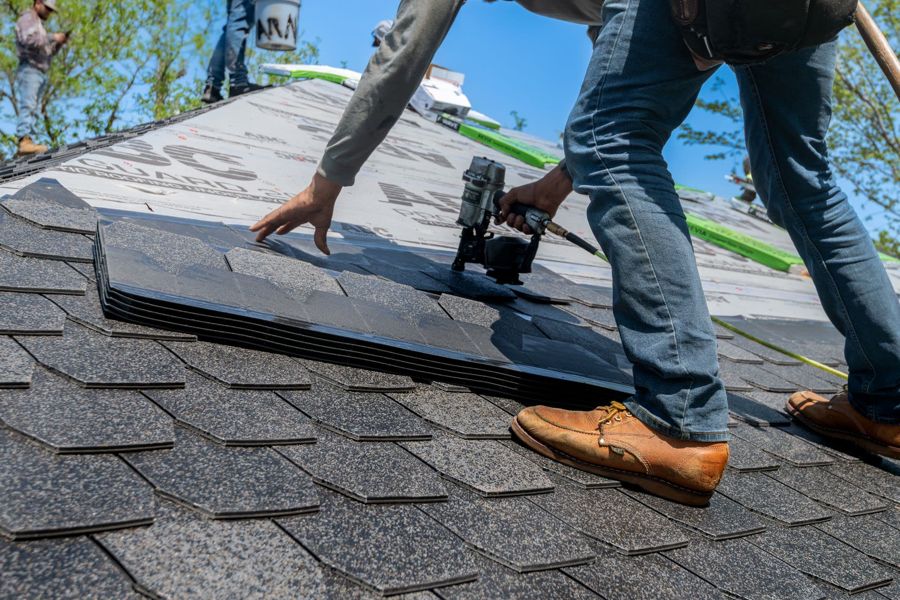 Roofers fixing slates in rows